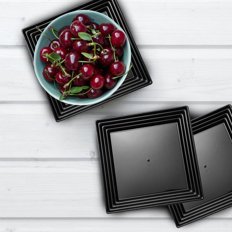 Black disposable serving tray with groove rim in a formal dining setup, presenting hors d'oeuvres