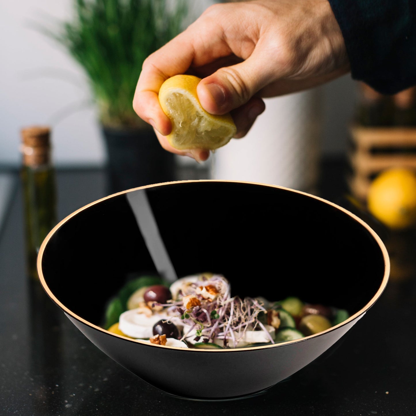 Black with Gold Rim Organic Round Disposable Plastic Dessert Bowl (6 oz.) elegantly presented with olives and a fresh, colorful salad
