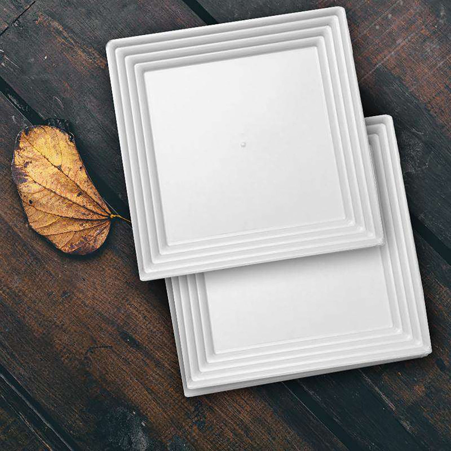 Bulk set includes 8 packs of 3 white square plastic serving trays, totaling 24 trays, ideal for catering and large events