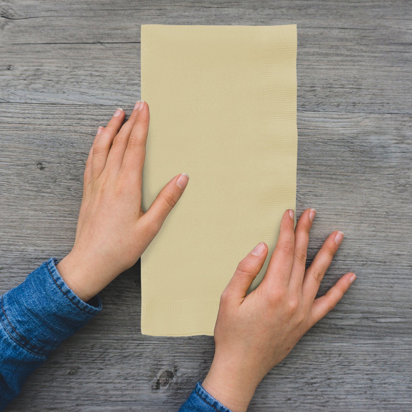 Close-up of ivory paper napkin showcasing soft embossed texture, unfolded to 16 x 16 inches, from 600-count case