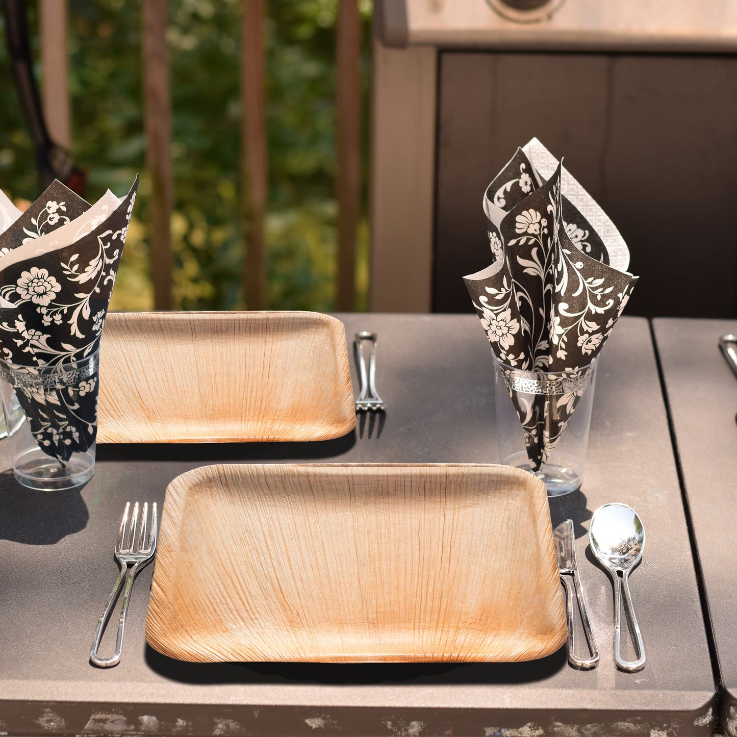 Natural square appetizer plates arranged at a sustainable event with linen runners and greenery accents.