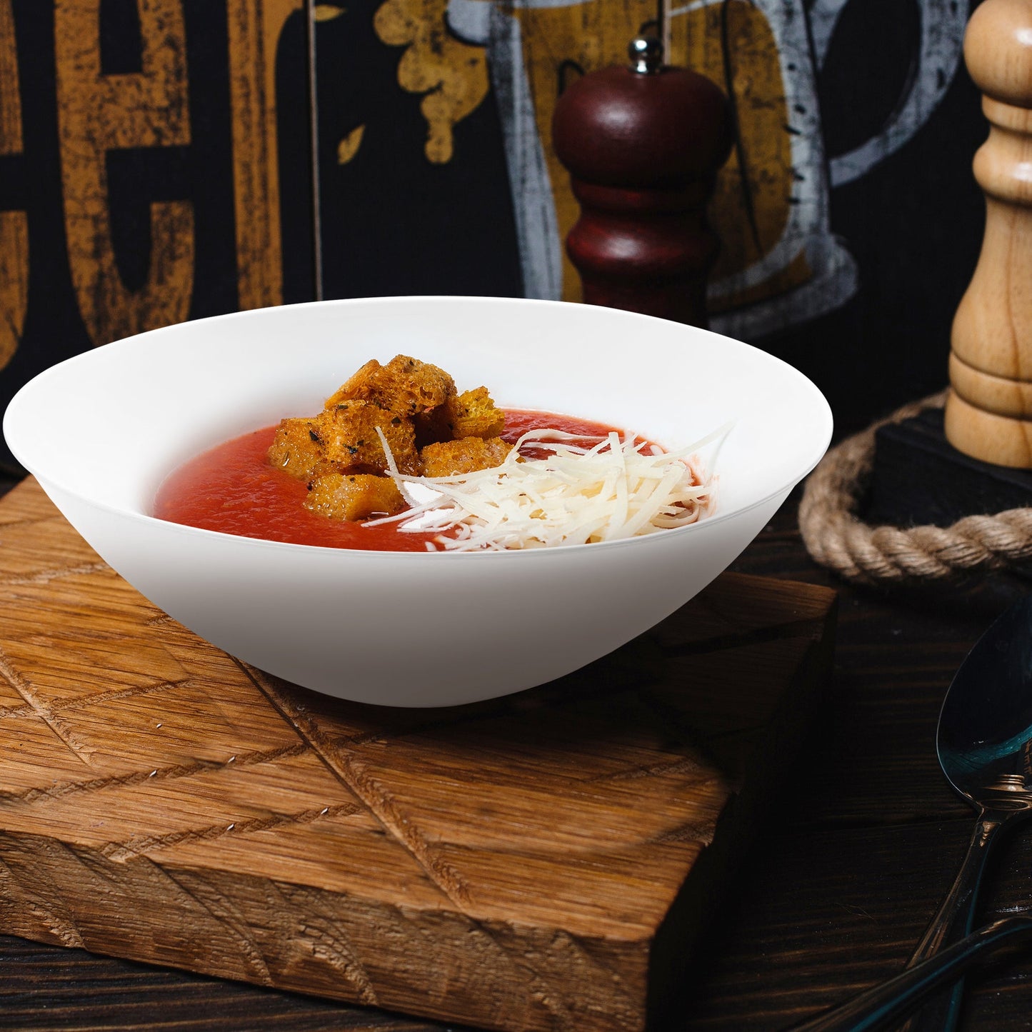 Solid White Organic Round Disposable Plastic Soup Bowl (16 oz.) filled with savory soup, topped with cube bread and melted cheese
