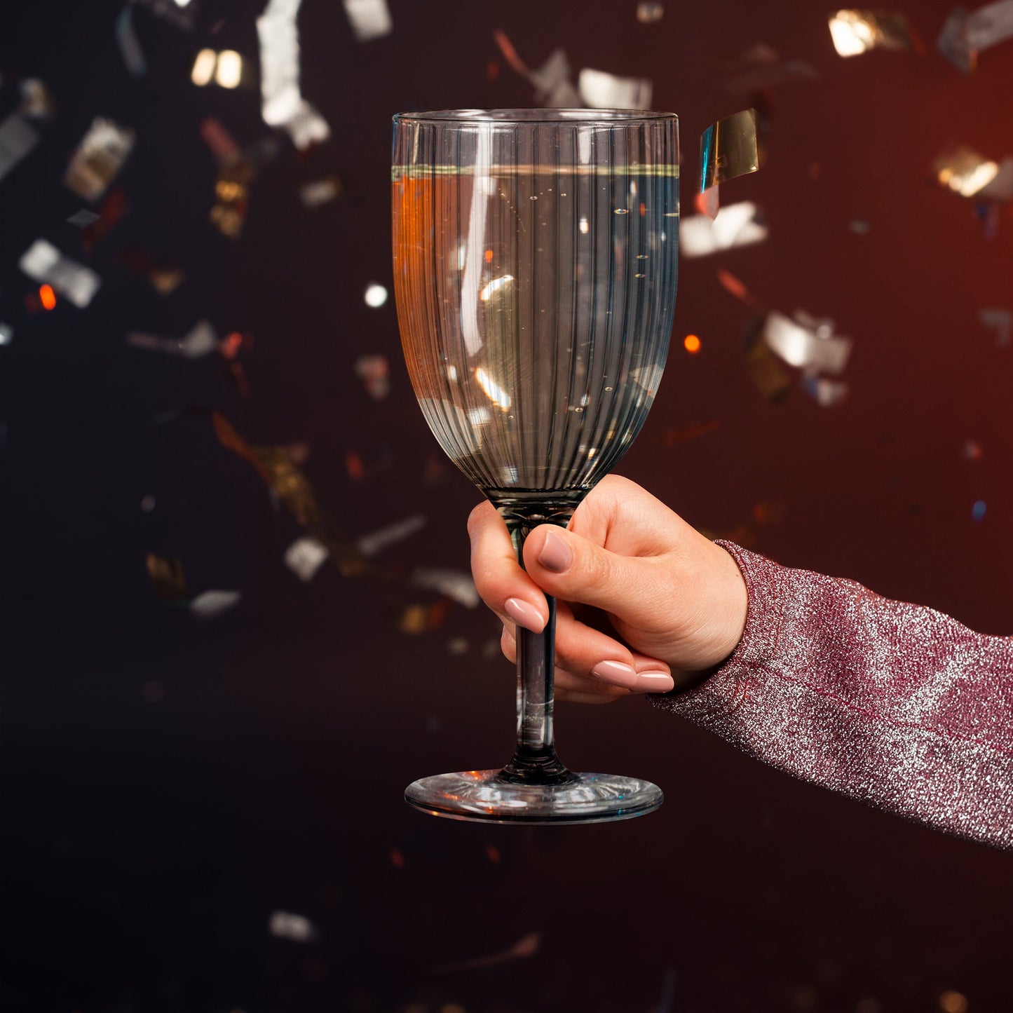 Wine flutes with clear stripe design on a rustic outdoor event table, filled with sparkling rose