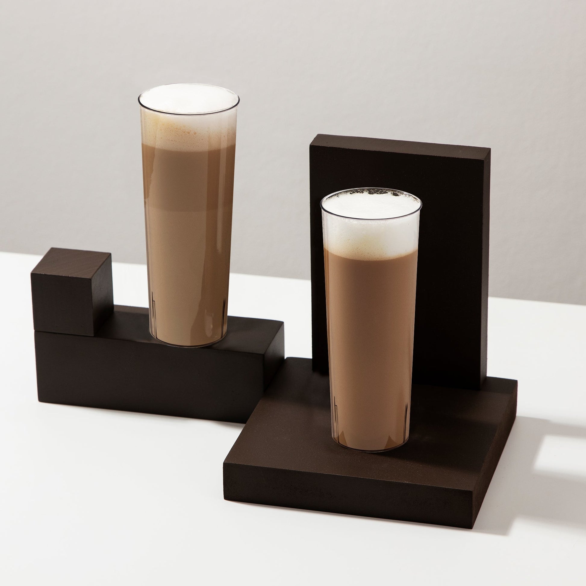 10 oz. Clear Round High Ball Disposable Plastic Cup filled with cappuccino, showcasing its clarity and tall design