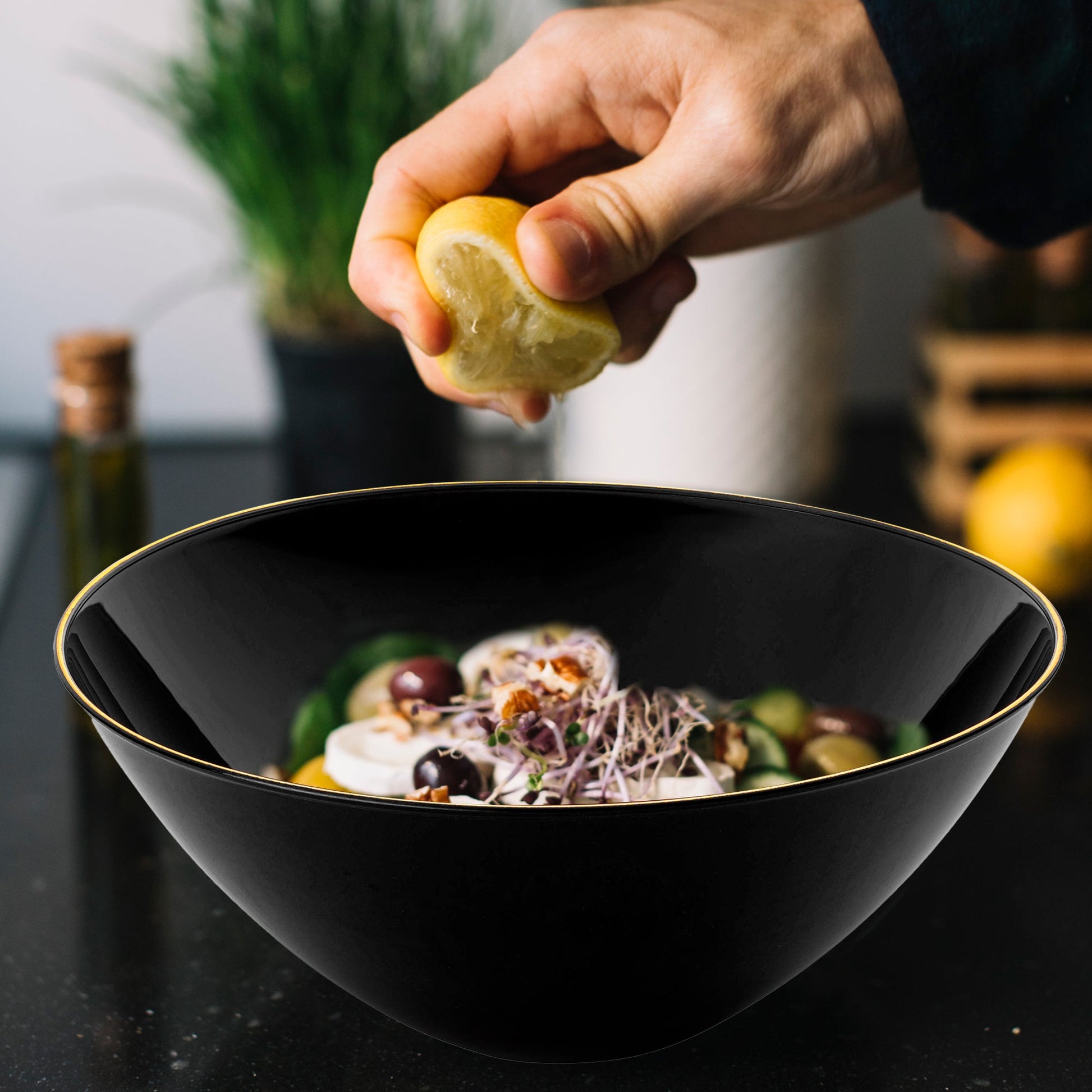 Black with Gold Rim Organic Round Disposable Plastic Bowl (32 oz.) elegantly presented with finely chopped salad and fresh greens