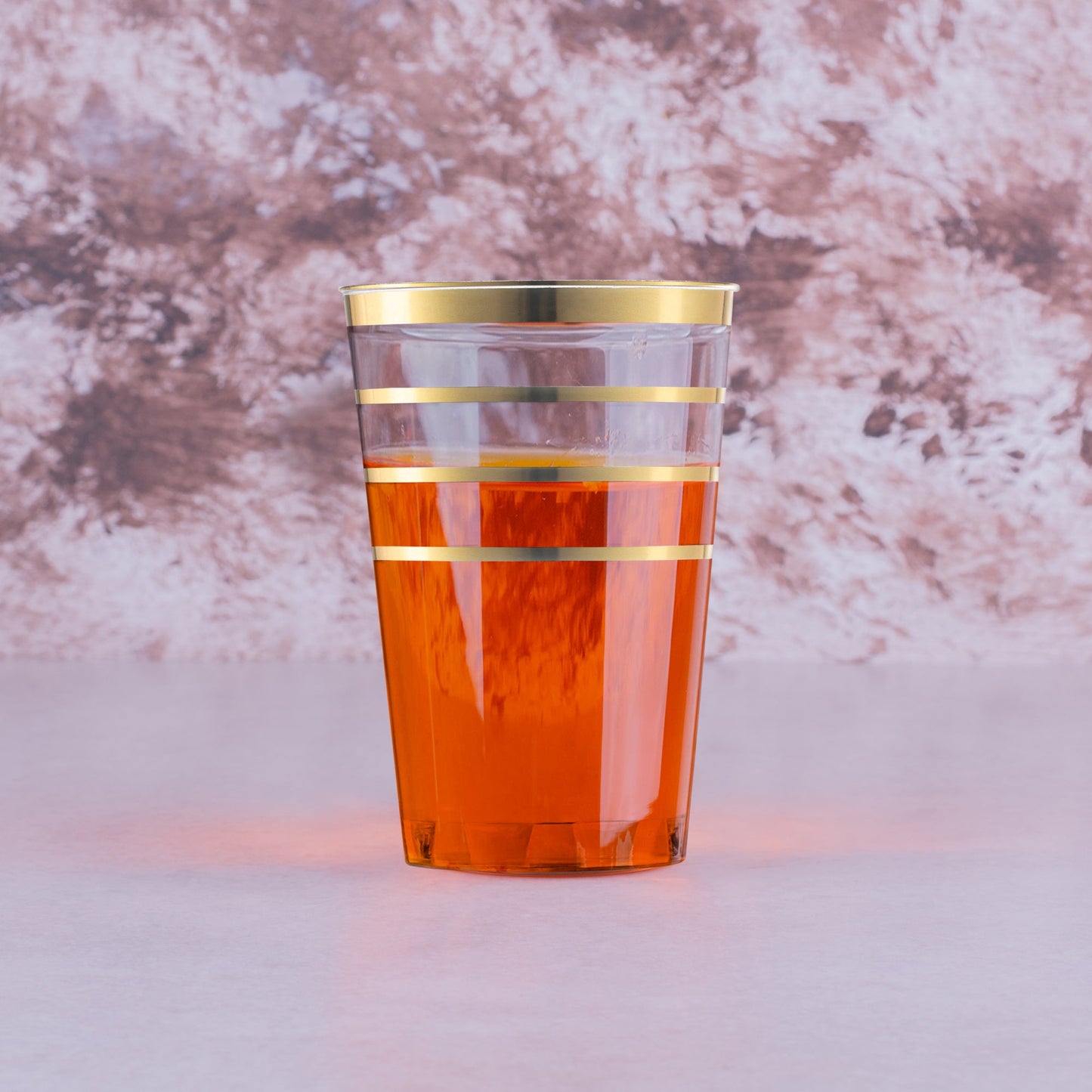 Elegant plastic tumbler with gold stripe accents, 12 oz. capacity, perfect for upscale events and party beverages