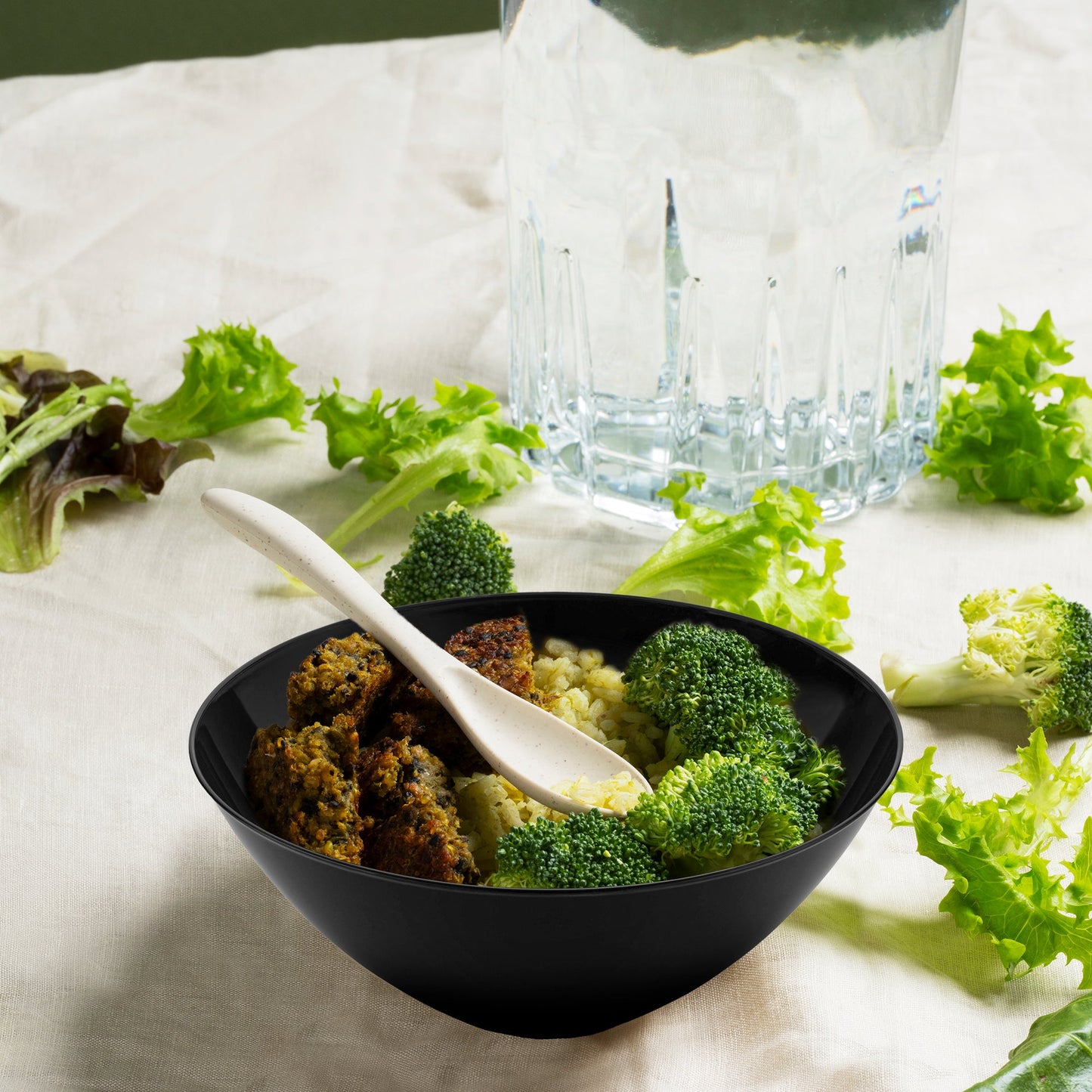 Solid Black Organic Round Disposable Plastic Bowl (32 oz.) served with grilled meat, seasoned rice, and steamed broccoli.